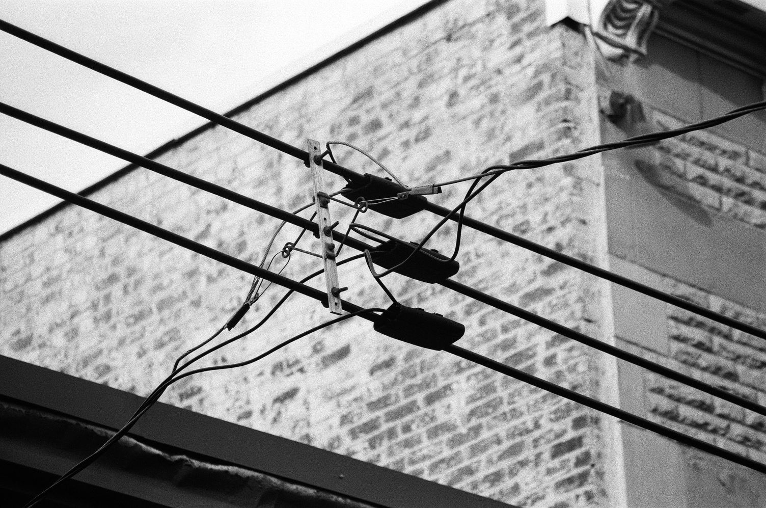 three vertically stacked power lines
at a junction where two sets
of three smaller cables
go off in opposite directions.
the dark lines contrast nicely
against the lighter background.