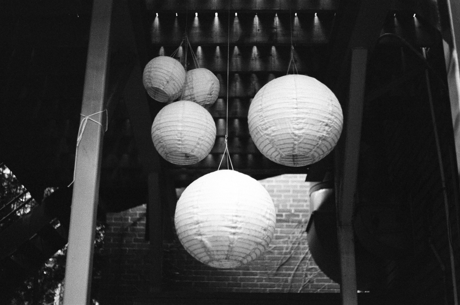 some round white paper lantern type things
hanging under an elevated deck.