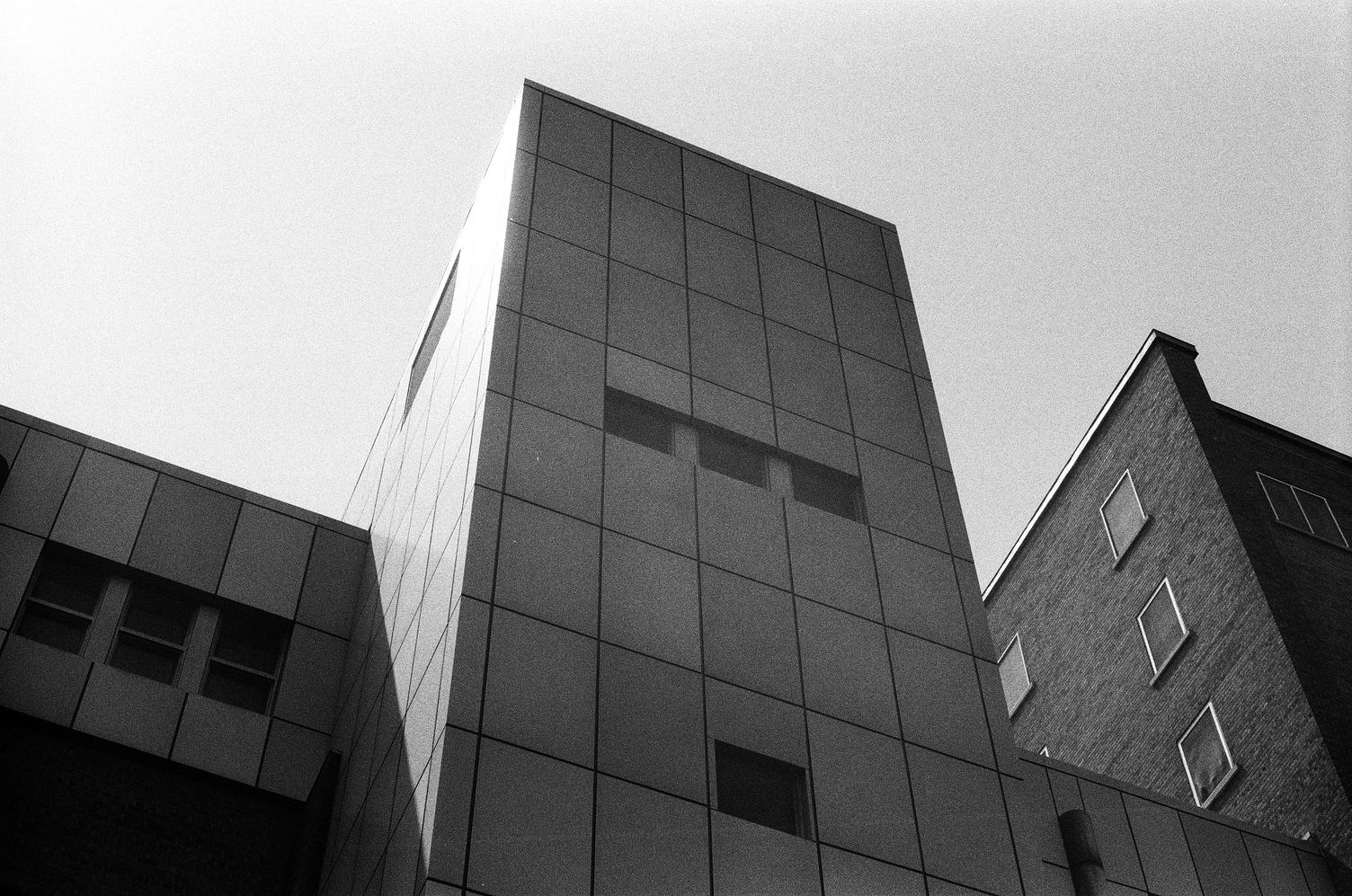 the cube.
the rectangle.
it's a modern part of a building
that's been added onto over time.
and it's just a big rectangle
with like a dev texture on it
and some weirdly placed windows.
we're looking up at it
from an angle
and the sun is hitting the top corner of it.
it looks imposing.