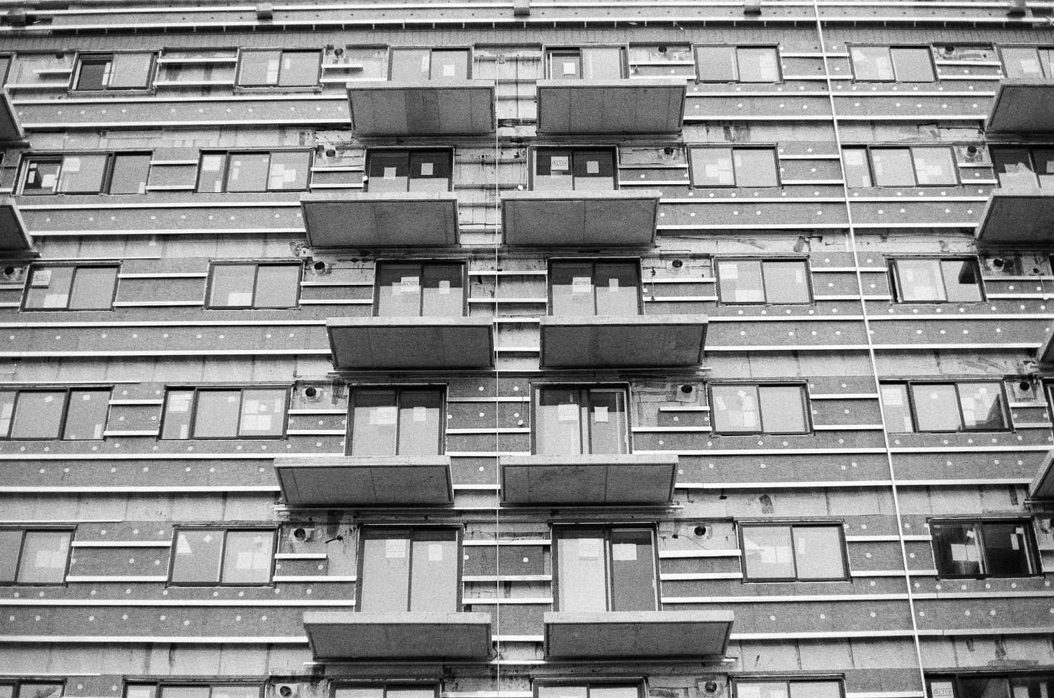 the front of a large apartment block
under construction
which hasn't yet
had its exterior wall installed.
there are balcony platforms
jutting out from the building
with no walls or railings.