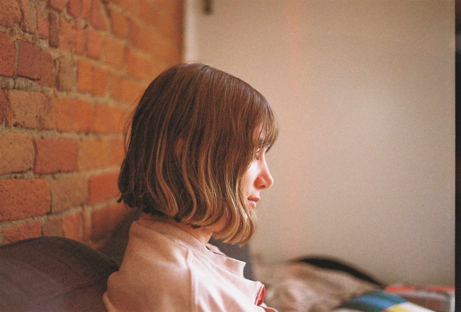 profile of Ayla on the couch in our apartment.
behind her on the left of the frame is a warm brick wall.
there's a band from what might be a light leak
just to the right of her head.
I've DIY replaced the light seals
on this camera so we'll see how it looks
on the next roll.
there's also a narrow dark band
at the right edge of the frame.
I don't know what's up with that.