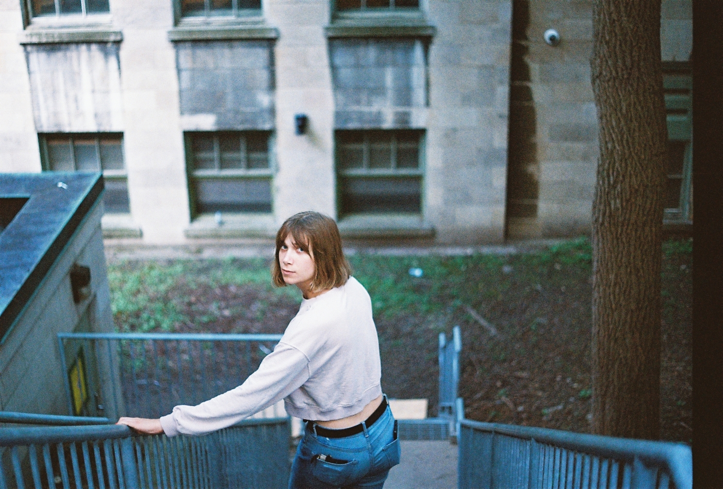 Ayla looking back
from halfway down a staircase
leading towards an old stone building.
there's a black band
of underexposed film
on the right edge of the frame.
a problem with the shutter
at slower speeds or something?